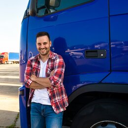 Ein Mann steht vor einem großen LKW
