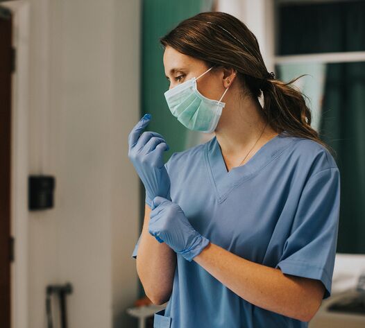 Personal trägt Schutzkleidung und Maske im Hygienebereich – Infektionsschutz und Arbeitssicherheit in medizinischer Einrichtung in Chemnitz